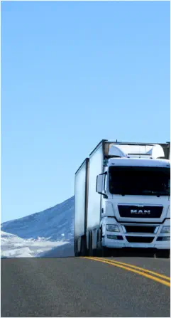 Premium enclosed double-trailer car carrier navigating snowy mountain terrain for secure nationwide winter vehicle relocation.